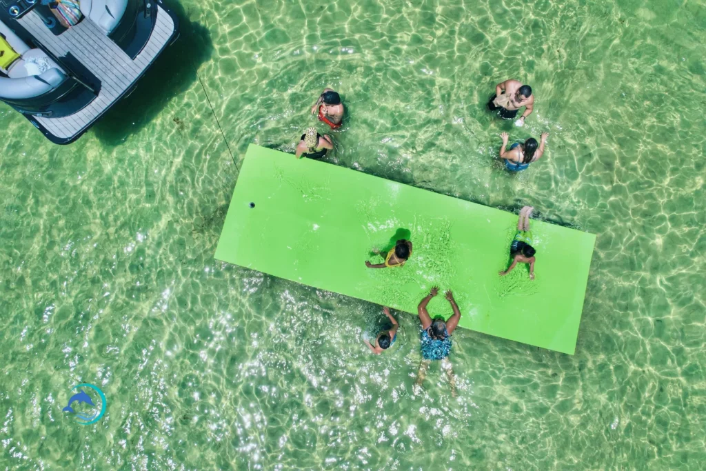people playing at Crab Island on a green mat, how do I get to Crab Island, Destin boat rentals, when is the best time to visit Crab Island, boat charters in Destin Florida