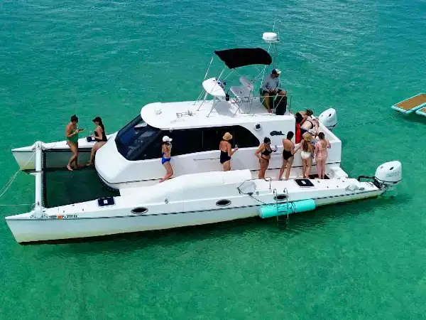 People enjoying a private yacht at Crab Island, crystal clear waters, perfect for luxury adventures.