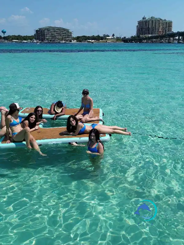 Stunning clear waters with group relaxing on floating platforms at Crab Island. Perfect for luxury beach adventures in Destin, FL