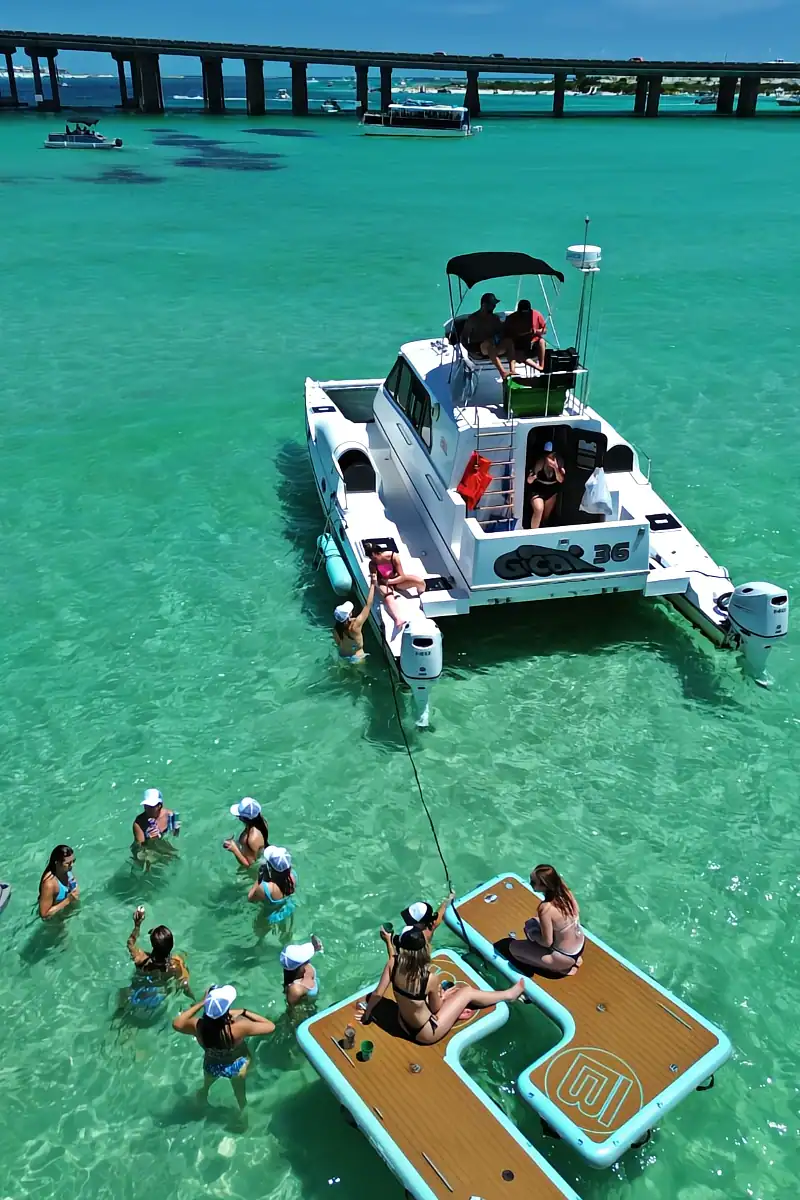 Bachelorette party celebrating on floats near a Catamaran yacht at Crab Island