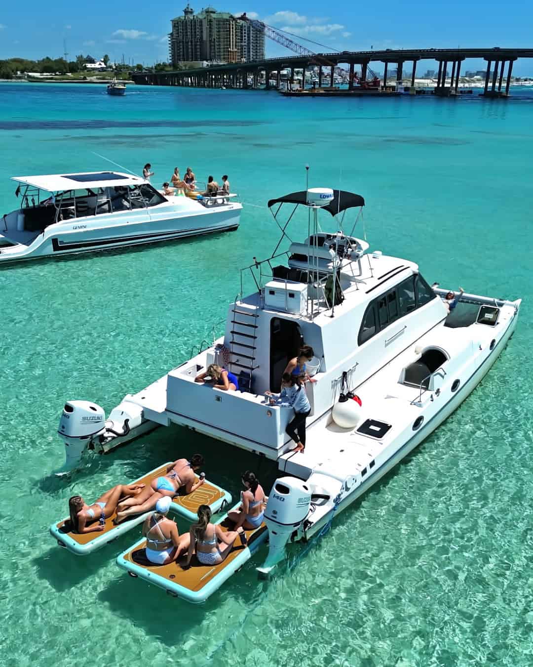 White catamaran anchored at Crab Island Destin, Florida with girls playing on BOTE floats