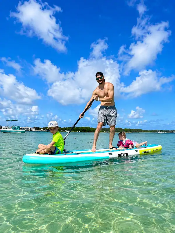 Dad on a paddleboard with his two kids at Crab Island