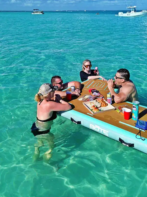 A group of people using BOTE floats as their table for lunch at Crab Island