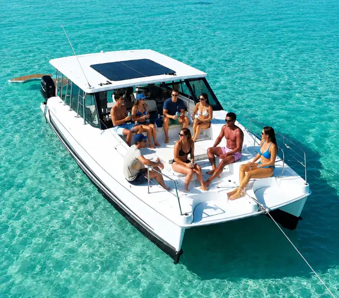 White catamaran with a group of people hanging out on the front deck while anchored at Crab Island