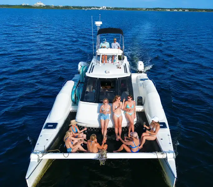 Girls riding on the front of a Catamaran headed for Crab Island with Crab Island Luxury Adventures