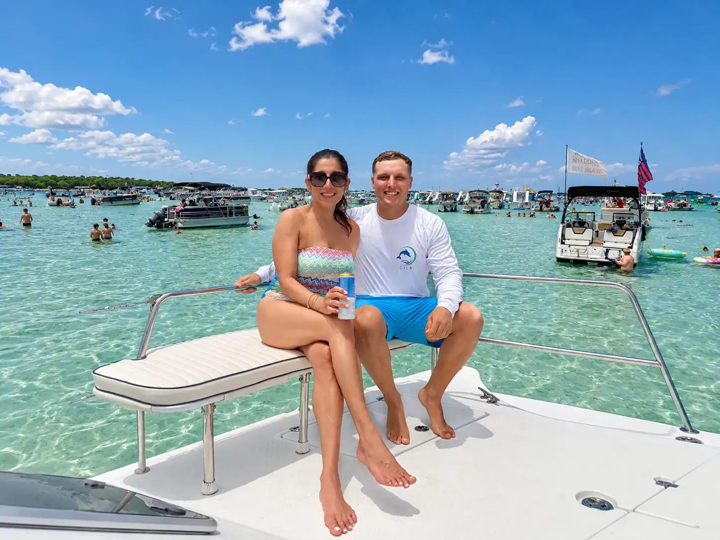 Couple sitting on the deck of a catamaran anchored at Crab Island